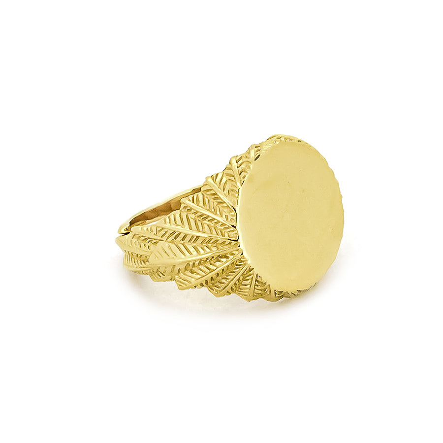 Beautiful gold ring with a smooth circular top and ornate feather-patterned band.

