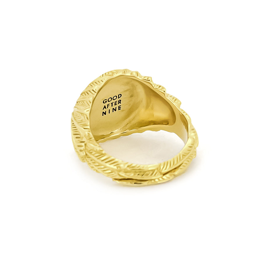 Elegant gold ring with a smooth circular top and ornate feather-patterned band.
