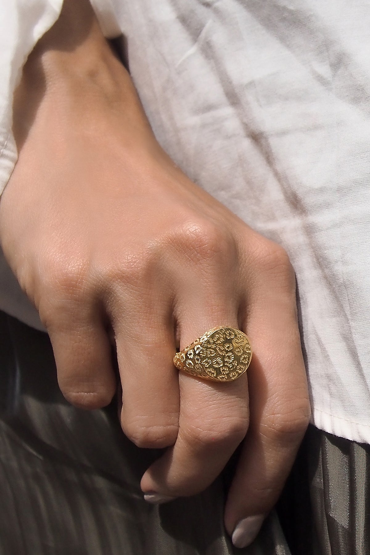 A close-up of a hand adored with gold ring  featuring a leopard print.