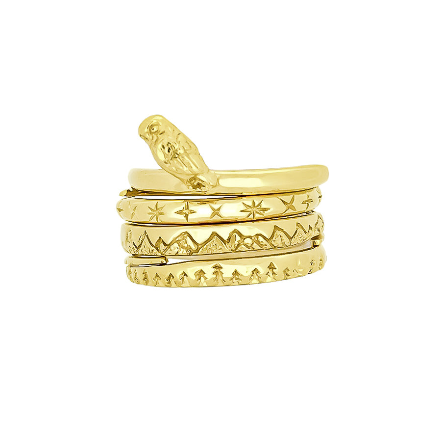 Beautifully designed gold stacking rings featuring nature-inspired designs: an owl, stars, mountains, and trees.